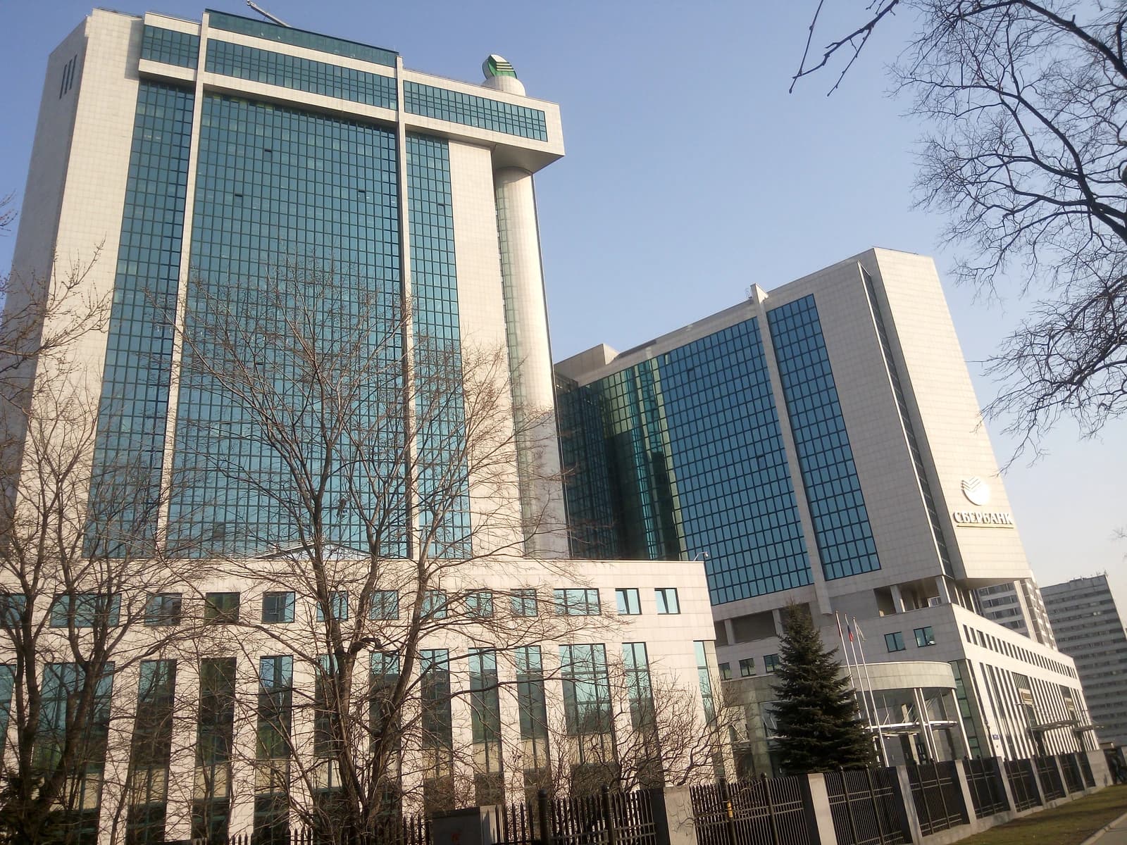 Sberbank headquarters building, a large structure with glass windows and a prominent Sberbank logo.