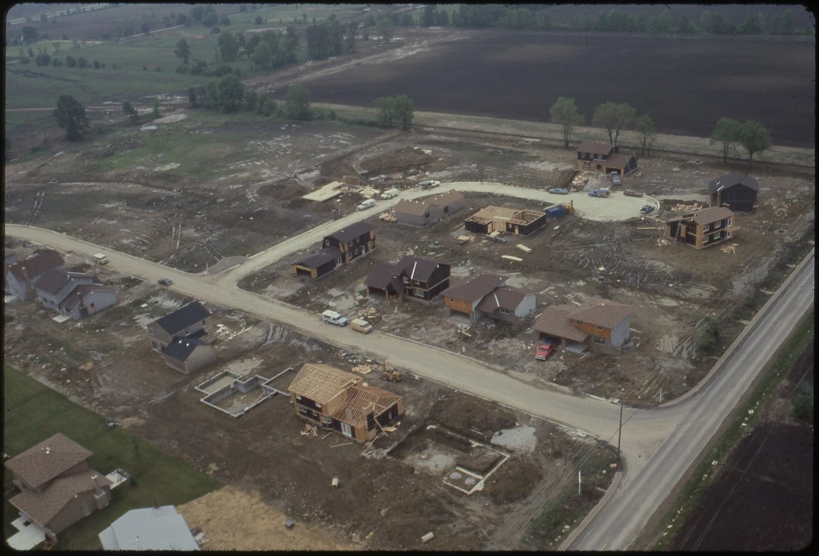 Aerial view of a housing development with multiple homes in various stages of construction.