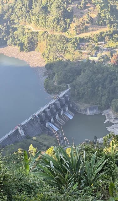 Aerial view of Ranganadi Dam in Yajali, Arunachal Pradesh, surrounded by lush green hills.