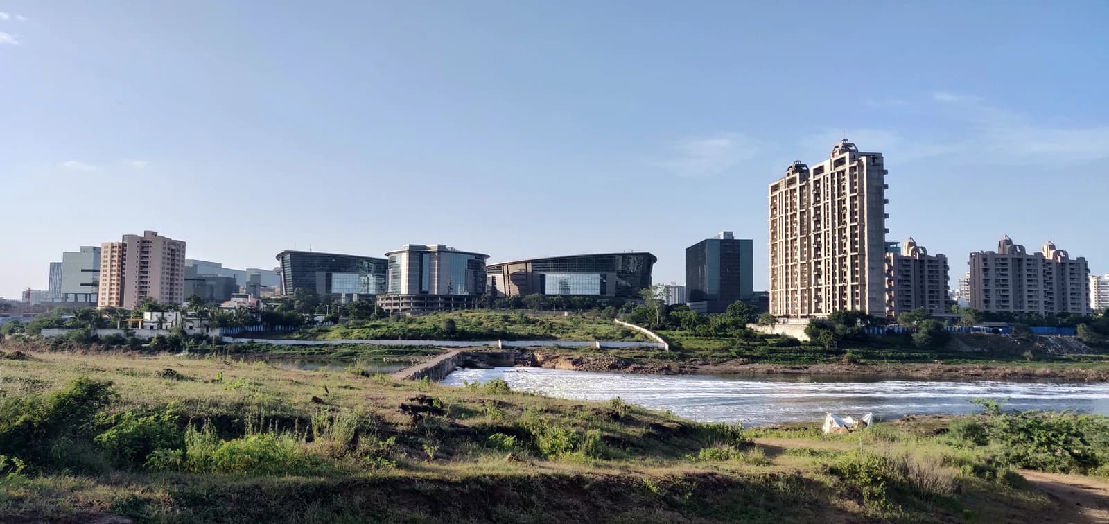 Skyline of Kharadi with corporate buildings and residential towers visible across a river.