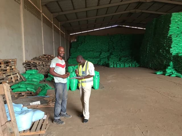 Warehouse manager and survey agent inspecting a rice cargo in a warehouse.
