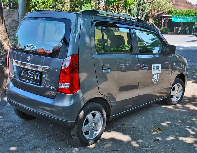Grey Suzuki Karimun Wagon-R parked on a sunny street in Denpasar.