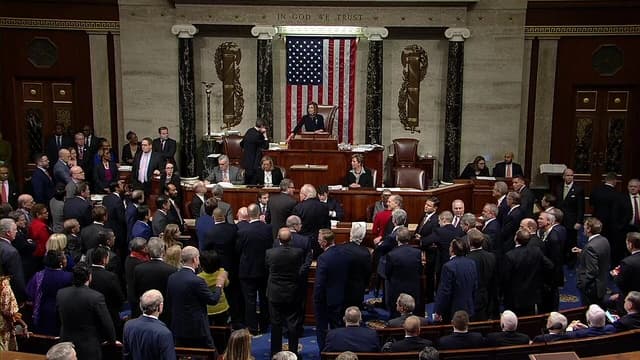 Members of the U.S. House of Representatives gather on the chamber floor.