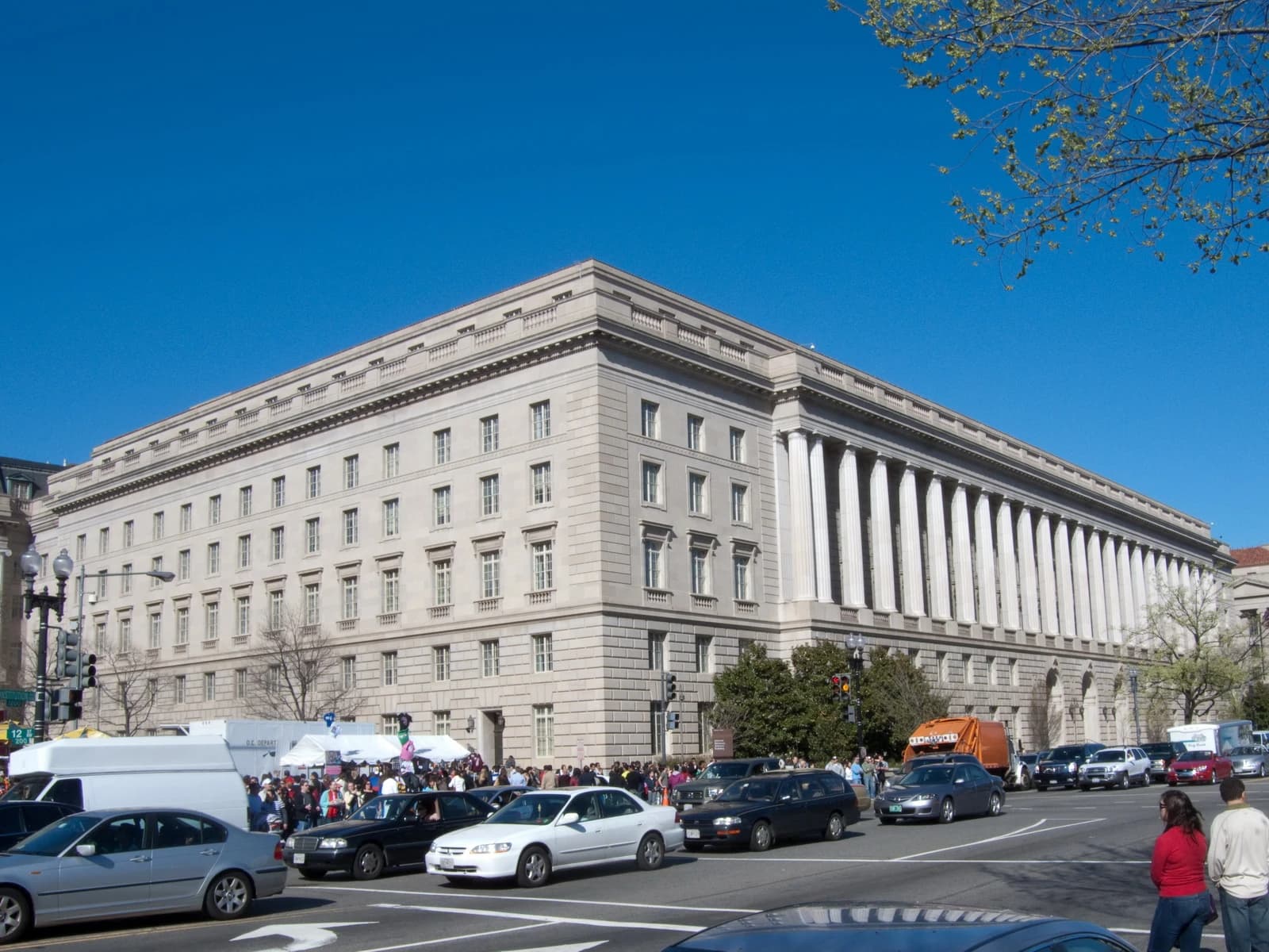 The IRS Building stands on Constitution Avenue in Washington, D.C. under a clear blue sky.