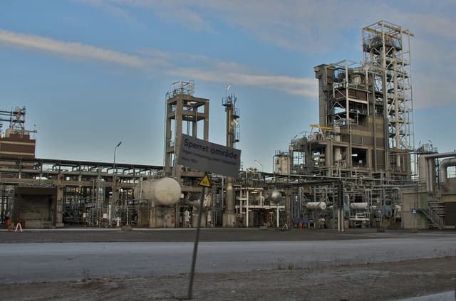 Petrochemical plant in Norway with various industrial structures under a blue sky.