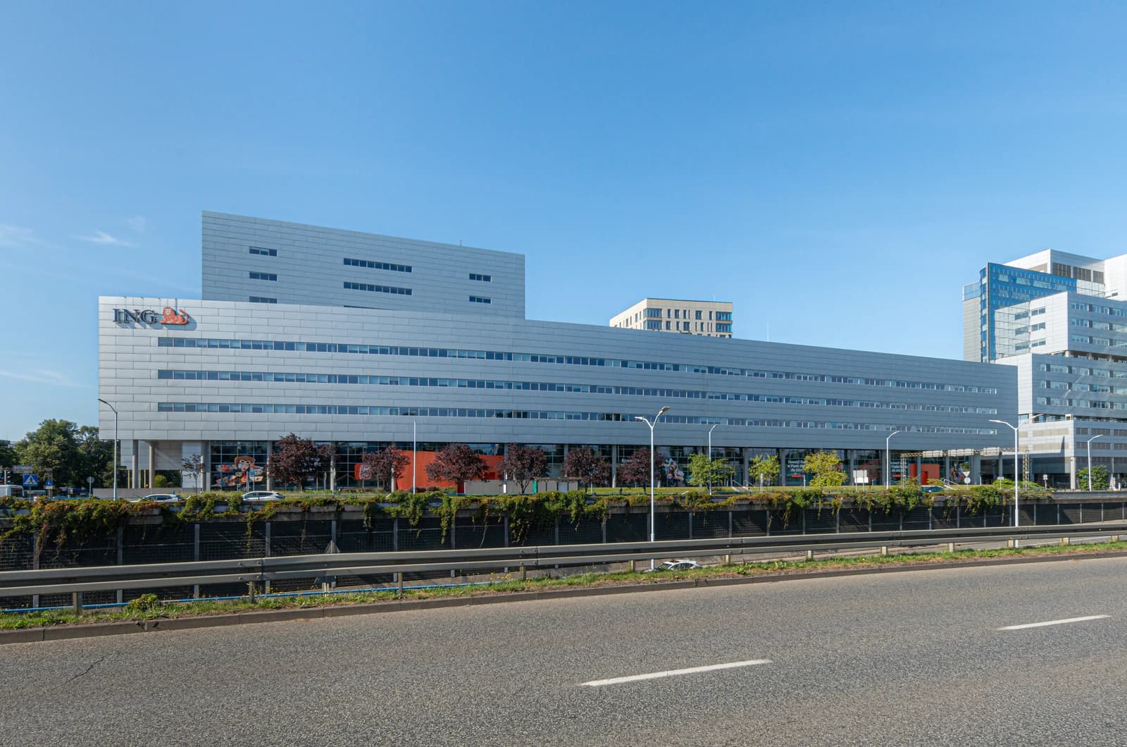 Modern office building with 'ING' logo visible on its facade, alongside a road.