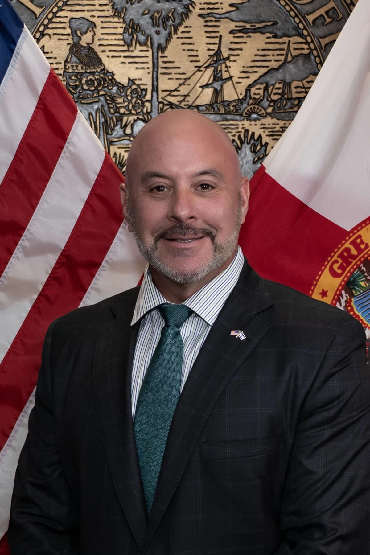 Blaise Ingoglia, Chief Financial Officer, poses for an official portrait against flags.