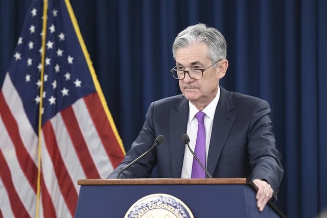 Jerome Powell, Federal Reserve Chair, speaking at a podium with microphones.
