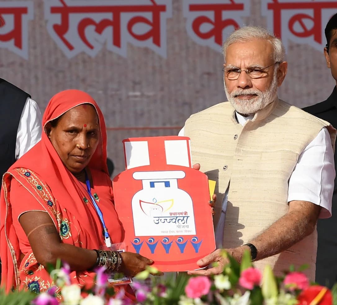 Narendra Modi, Prime Minister of India, hands a certificate to a woman.