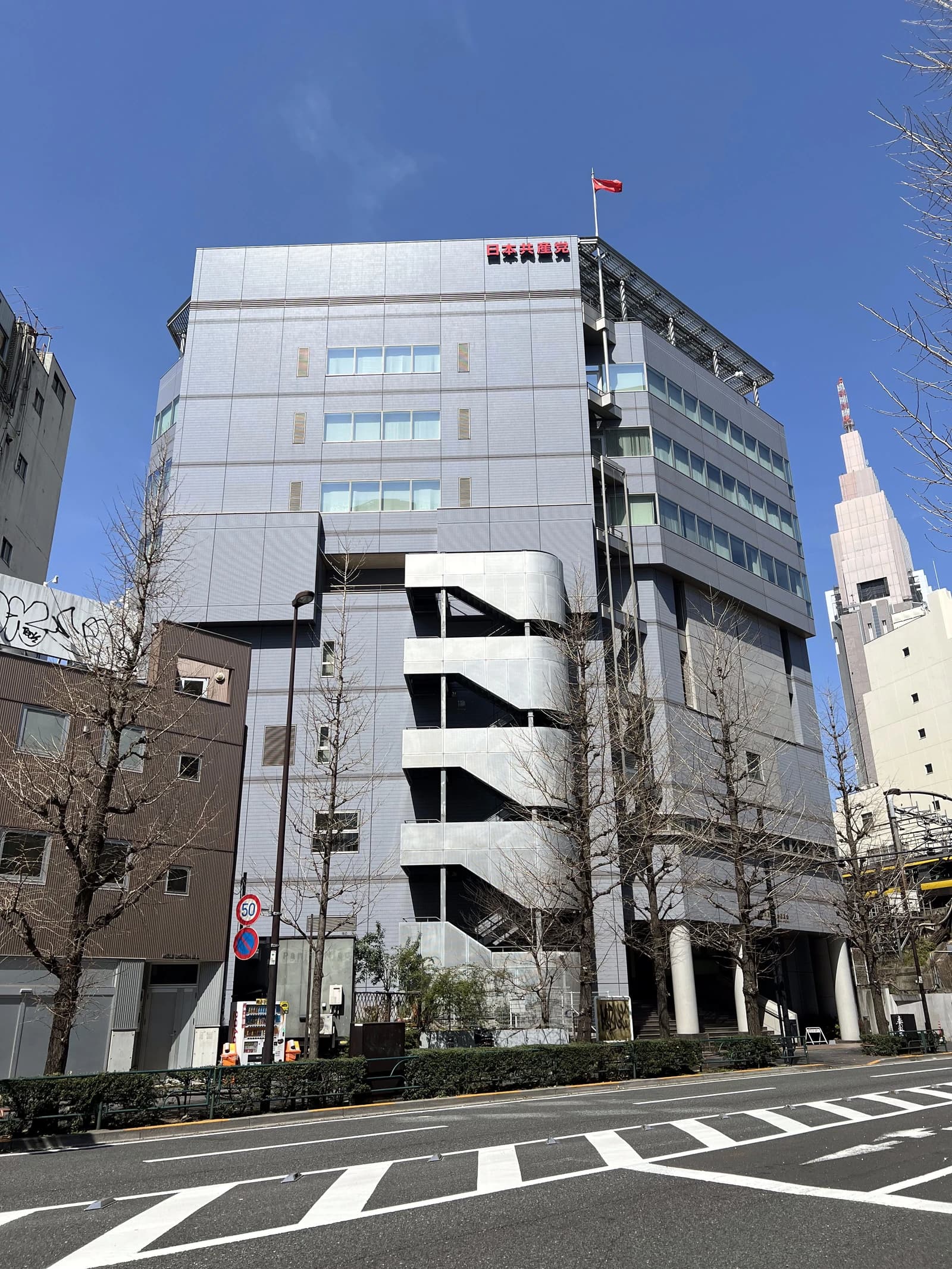 Japanese Communist Party headquarters building, a modern, multi-story structure with a red flag.