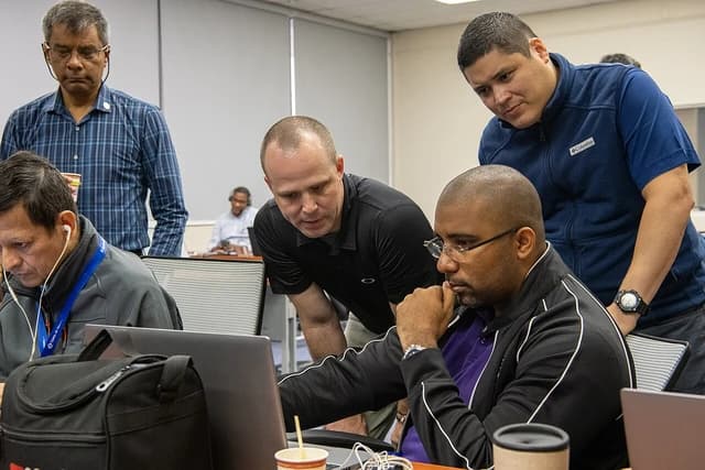 Men from Panama Aeronaval and Missouri National Guard working on laptops.