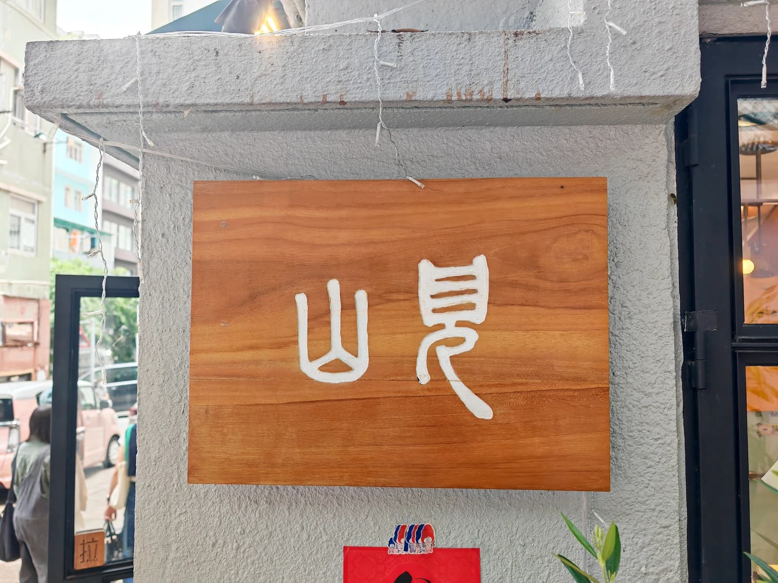 Wooden signboard with Chinese characters for Mount Zero Books on a building in Hong Kong.