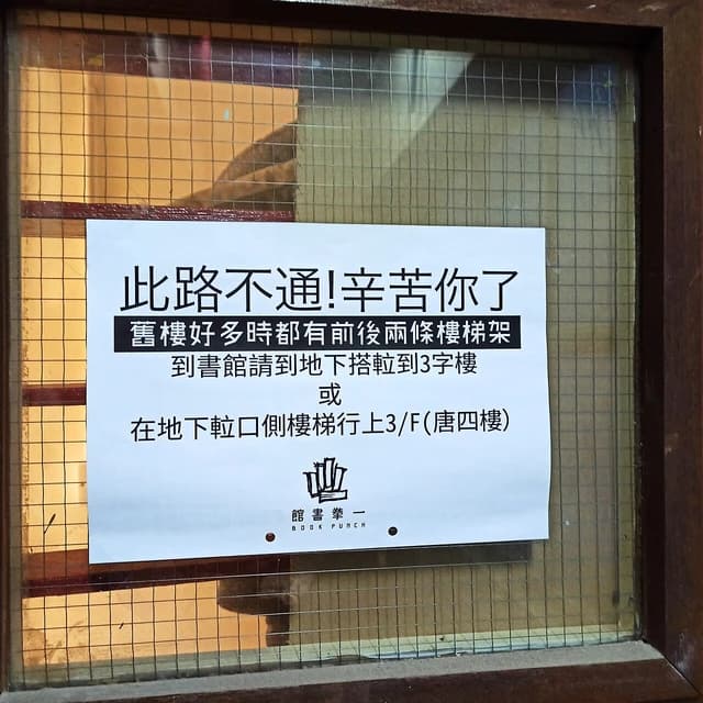 A white sign in Chinese and English text, including "BOOK PUNCH", on a glass door.