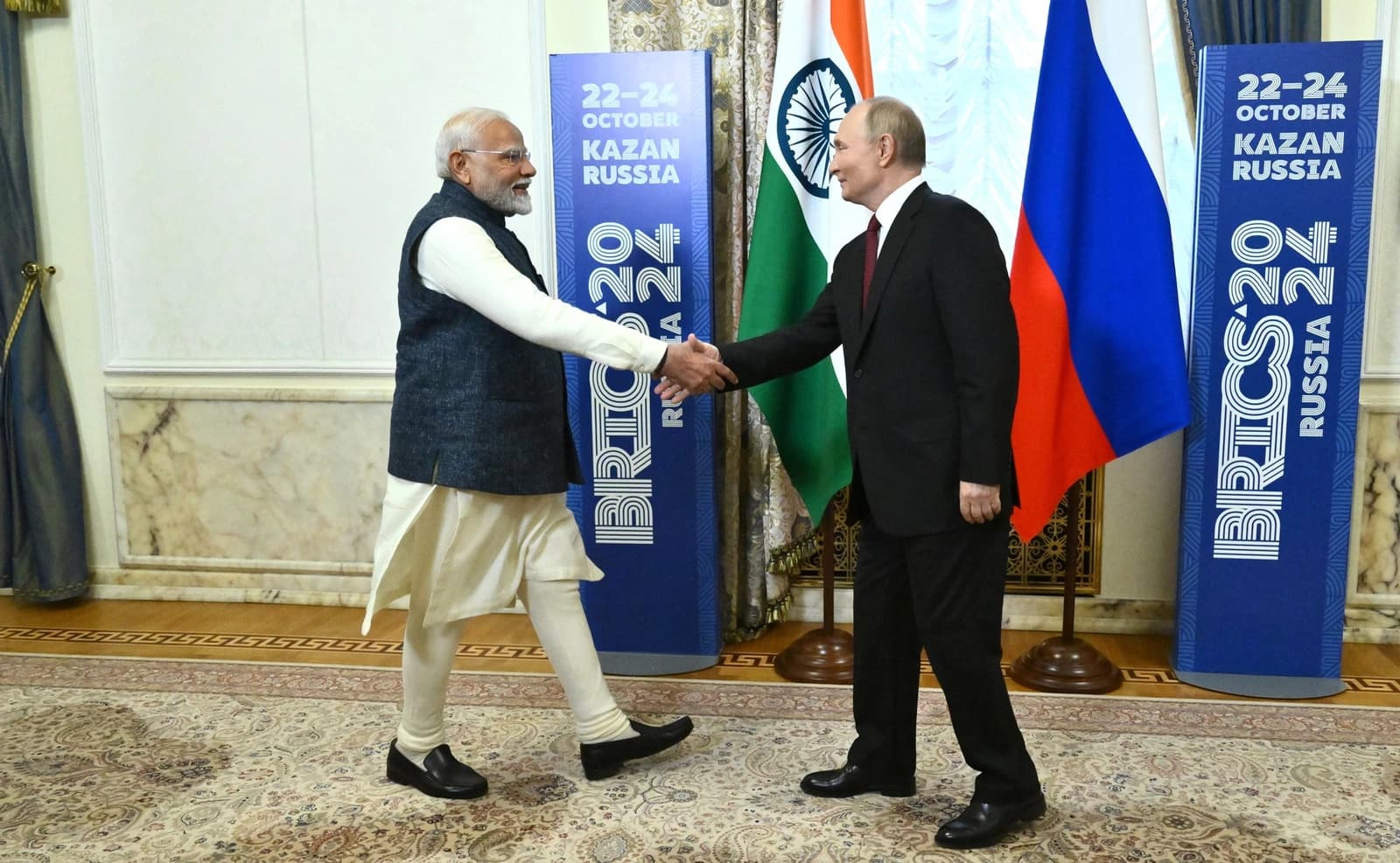 Russian President Vladimir Putin and Indian Prime Minister Narendra Modi shake hands.