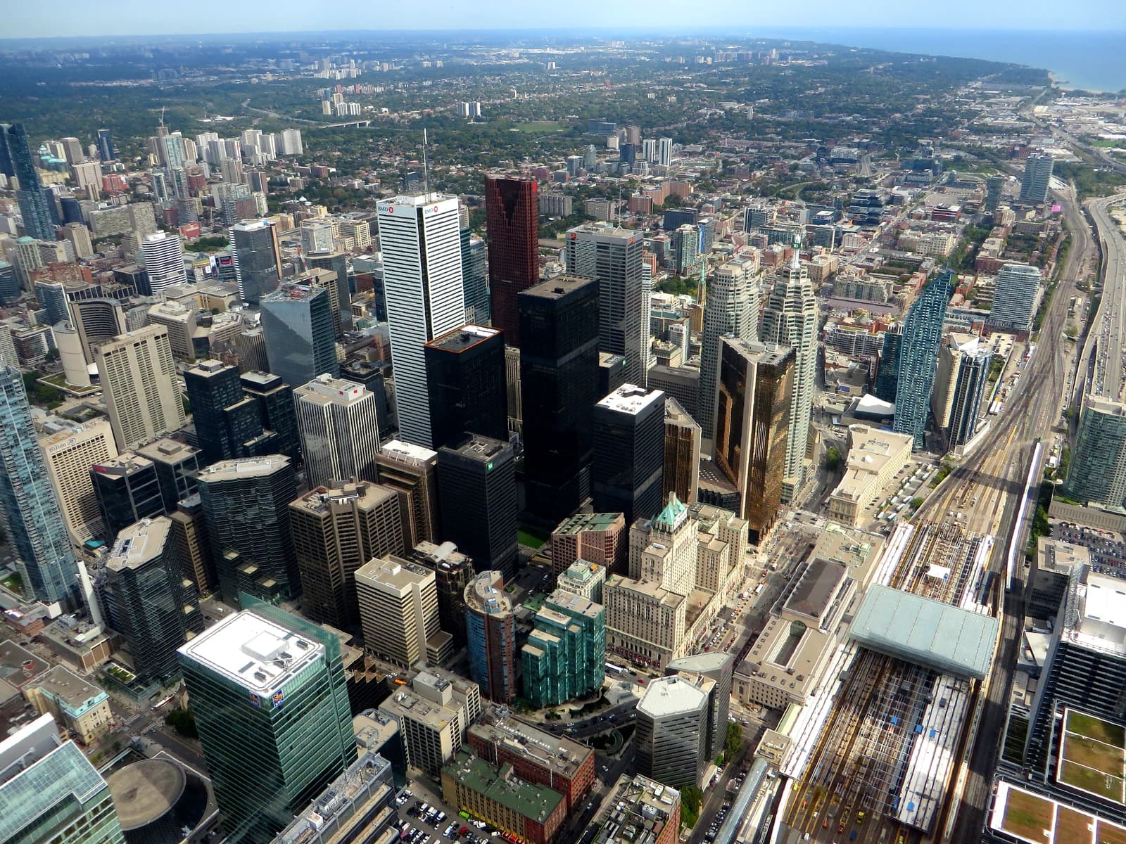 Aerial view of Toronto's financial district with skyscrapers and distant Lake Ontario.