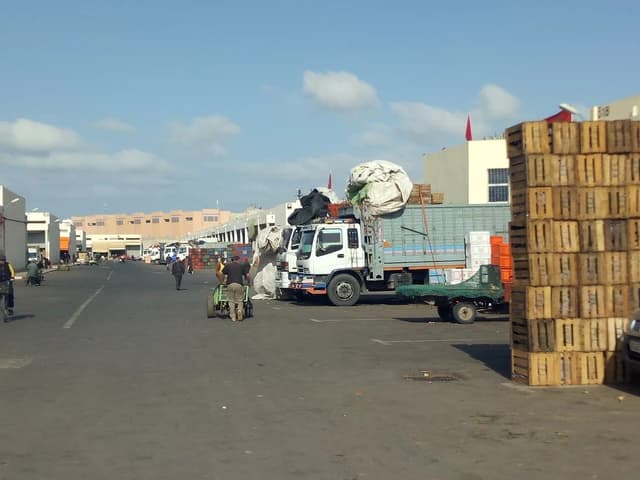 People and trucks at the wholesale and half wholesale vegetable and fruit market in Inezgane.