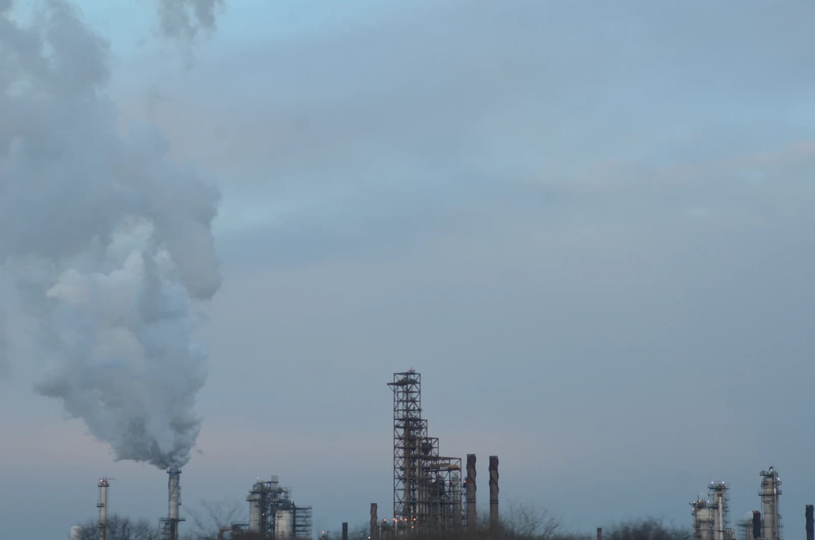ExxonMobil refinery in Joliet, Illinois, with smoke emitting from a tall stack.