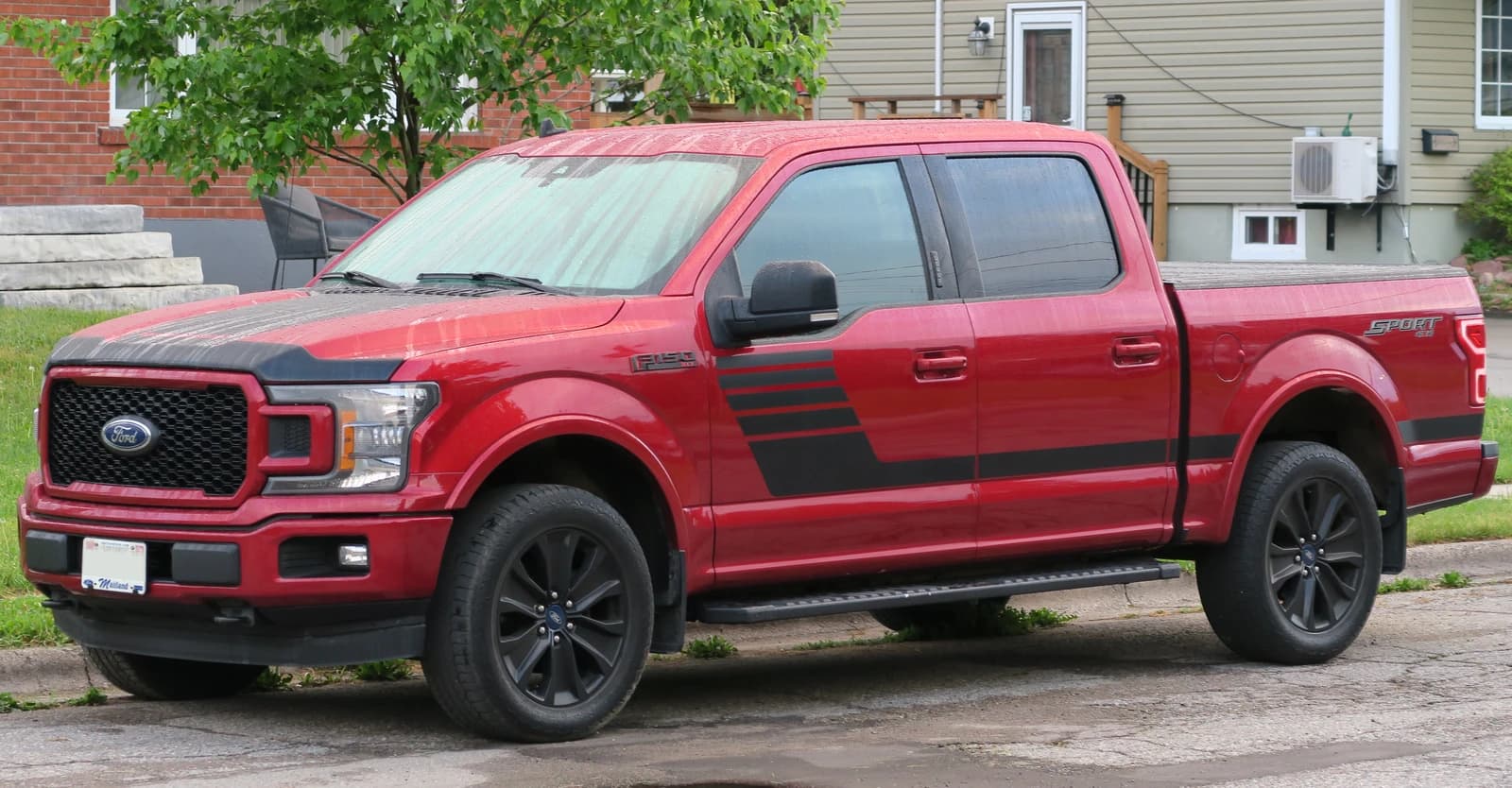 Red 2019 Ford F-150 XLT 4X4 Supercrew pickup truck parked on a street.