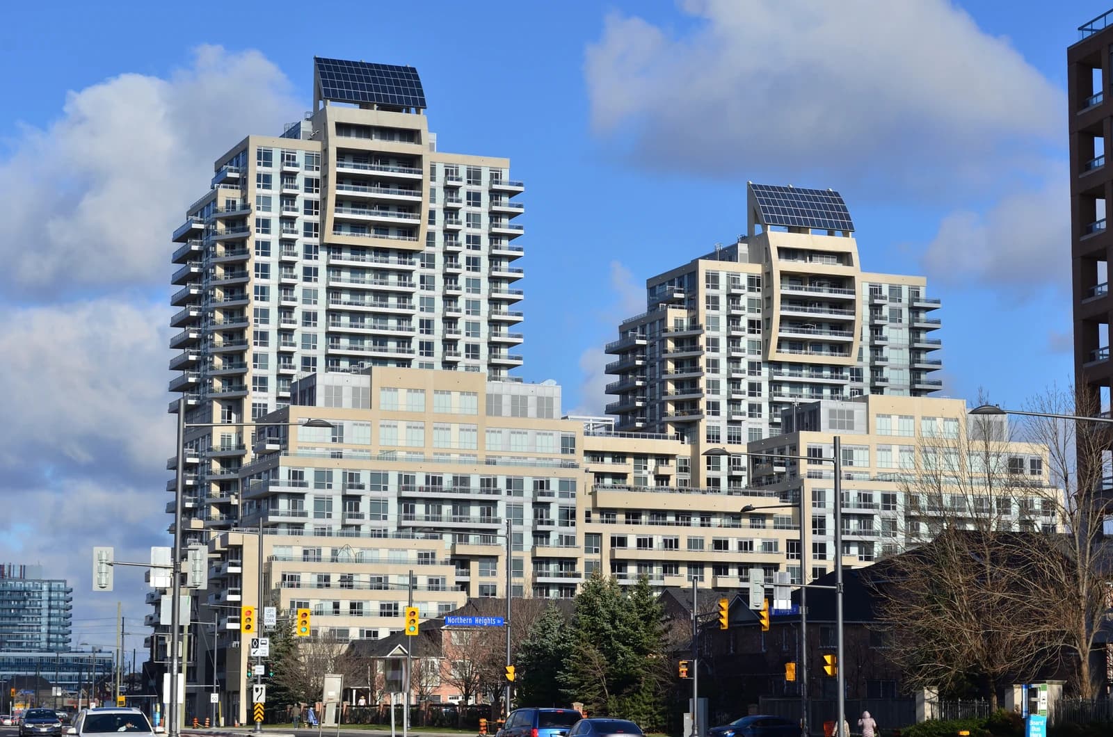 Solar panels on the rooftop of a modern high-rise condominium building.