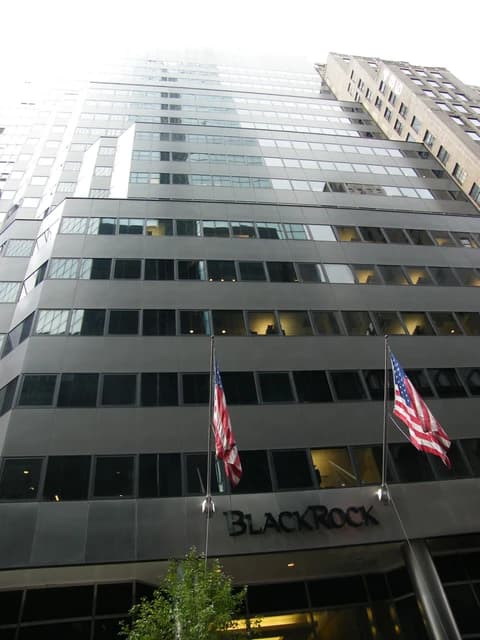 BlackRock company headquarters building with two American flags displayed at the entrance.
