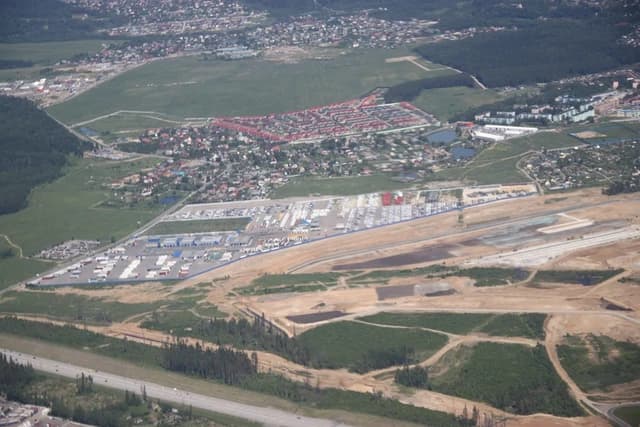 Aerial view of a large airport construction site with an unfinished runway.