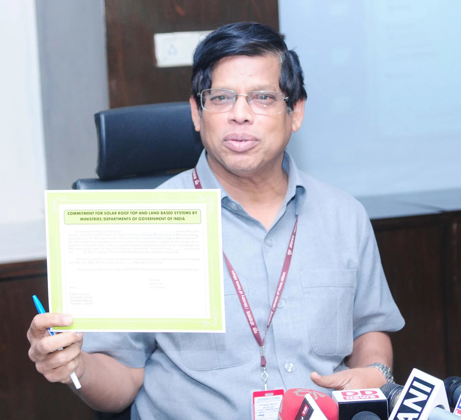 Upendra Tripathy, Secretary of New & Renewable Energy, holding a document at a press conference.