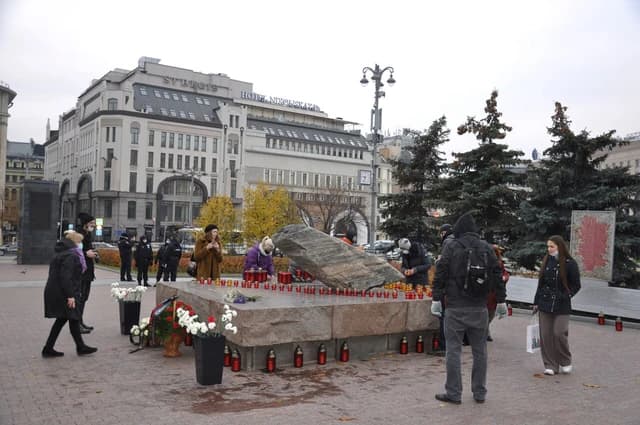 People gather to place candles at the Solovetsky Stone memorial in Moscow.