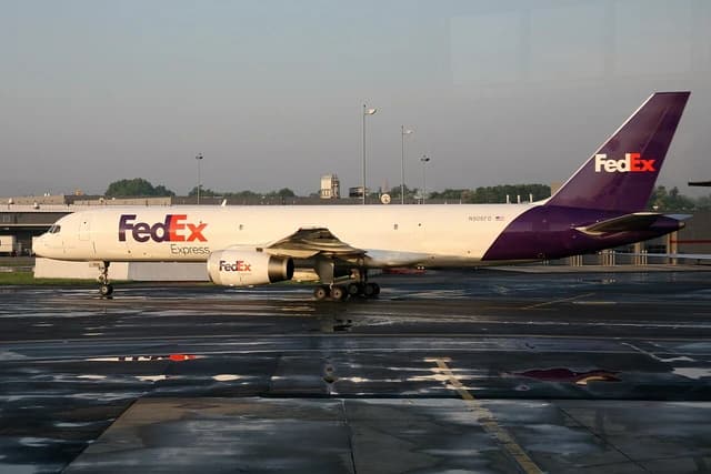 FedEx Boeing 757 cargo plane parked on the tarmac, seen from the side.