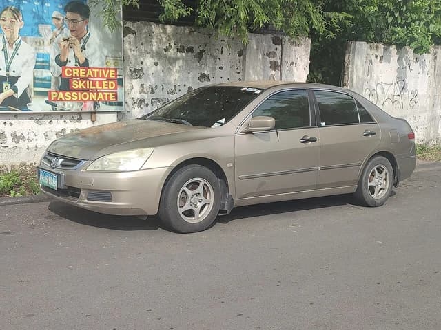 A beige 2006 Honda Accord 2.4 i-VTEC VTi parked on the side of a street.