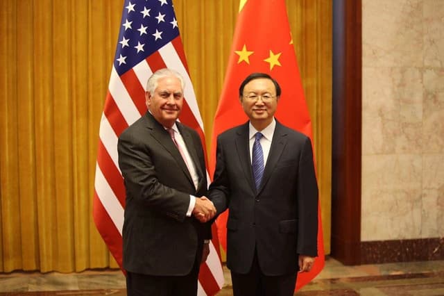 Rex Tillerson, US Secretary of State, and Yang Jiechi, Chinese State Councilor, shaking hands.