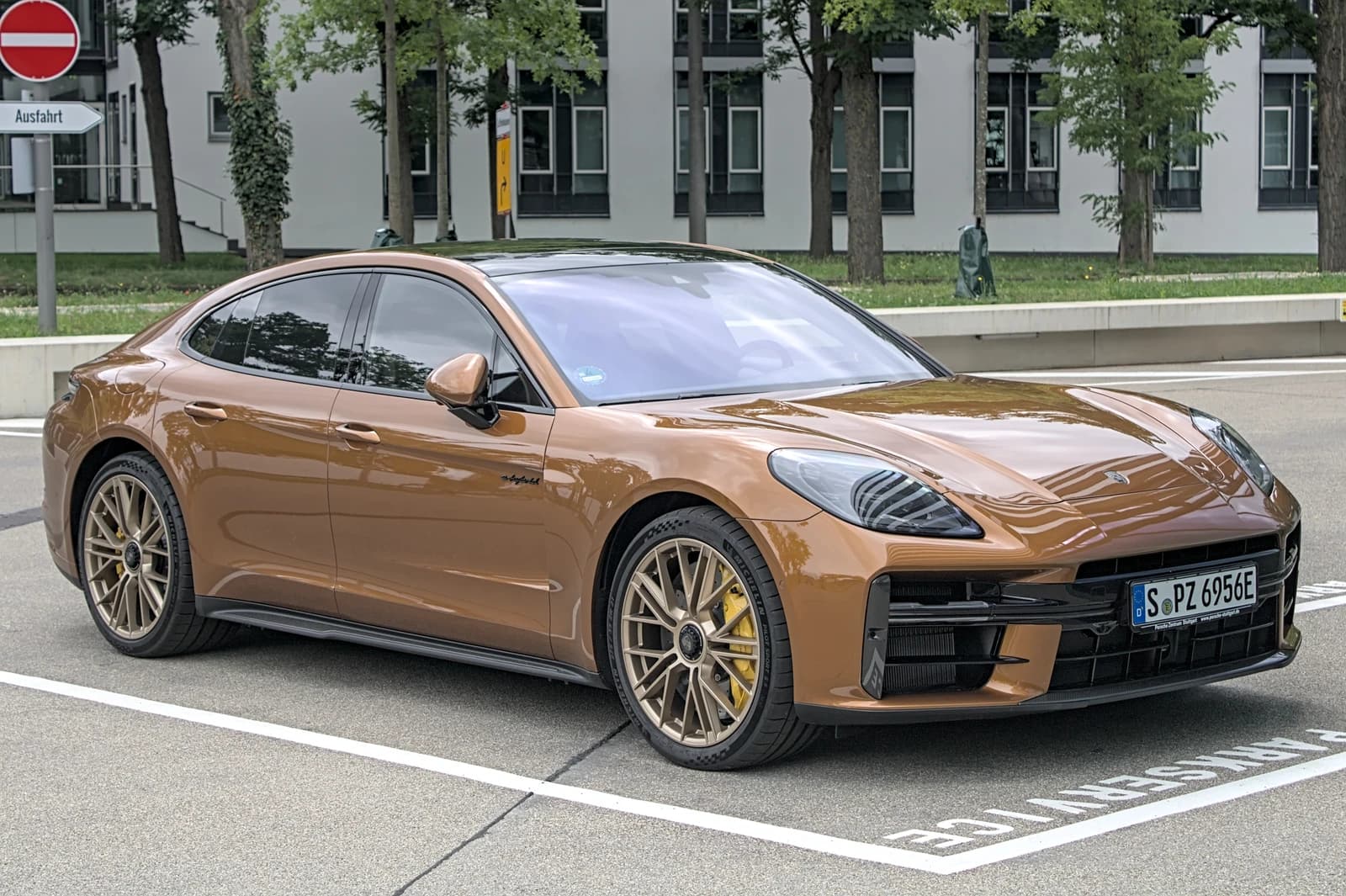 Porsche 972 Turbo E-Hybrid, a brown luxury car, parked in an outdoor space.