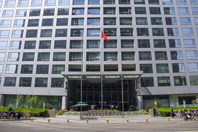 Exterior of the China Securities Regulatory Commission building with a red Chinese flag flying.
