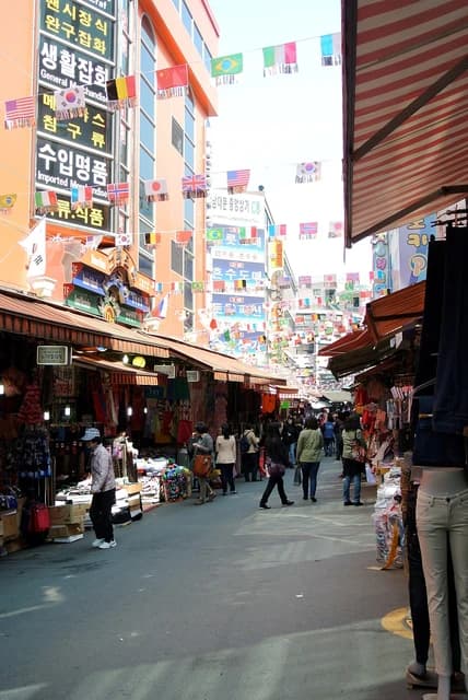 People walk through an alley lined with shops at Namdaemun Market in Seoul, South Korea.