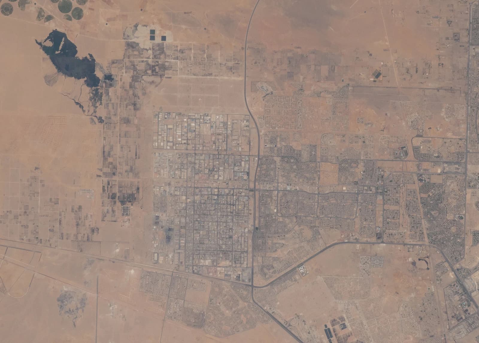 Aerial satellite image showing urban development and desert landscape in Egypt.