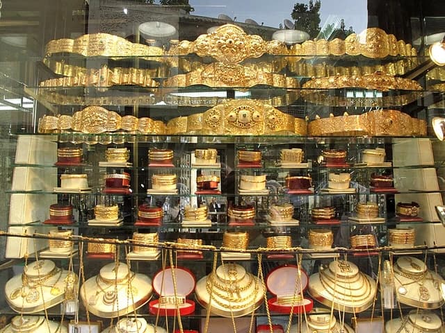 Gold bracelets and necklaces displayed in a jewelry store window in Marrakesh.