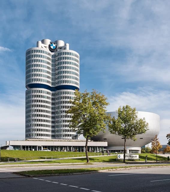 BMW Vierzylinder Tower and BMW Museum in Munich, Germany under blue sky.