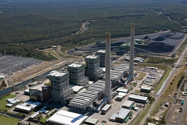 Aerial view of Eraring Power Station with coal piles and surrounding landscape.