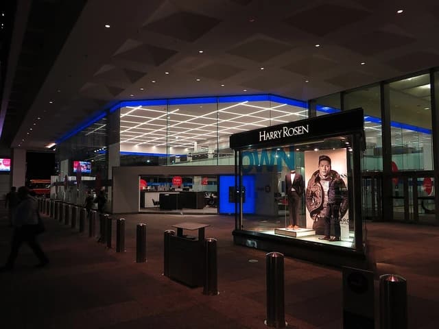Exterior of First Canadian Place in Toronto at night, with street level storefronts.