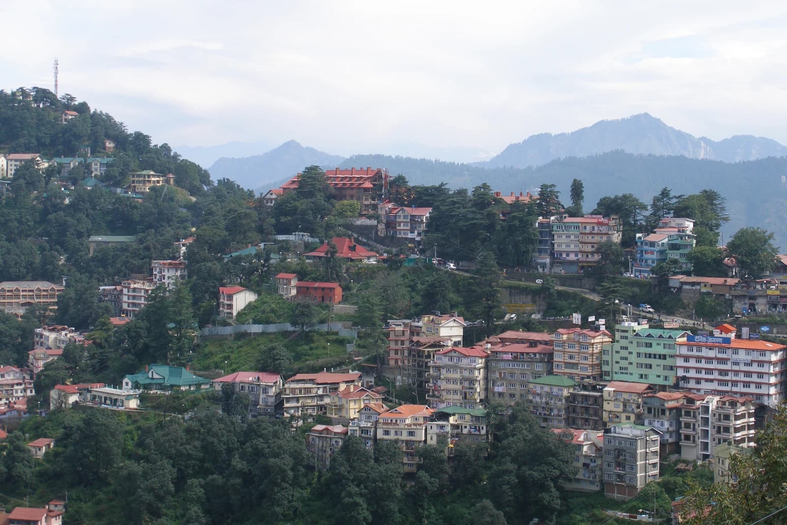 Panoramic view of Shimla hills in India with buildings scattered across the landscape.