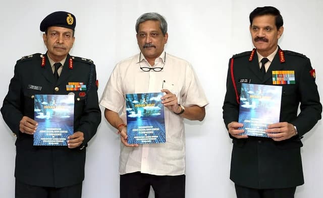 Manohar Parrikar and two Army officers hold brochures for the Army Cloud, Data Centre.