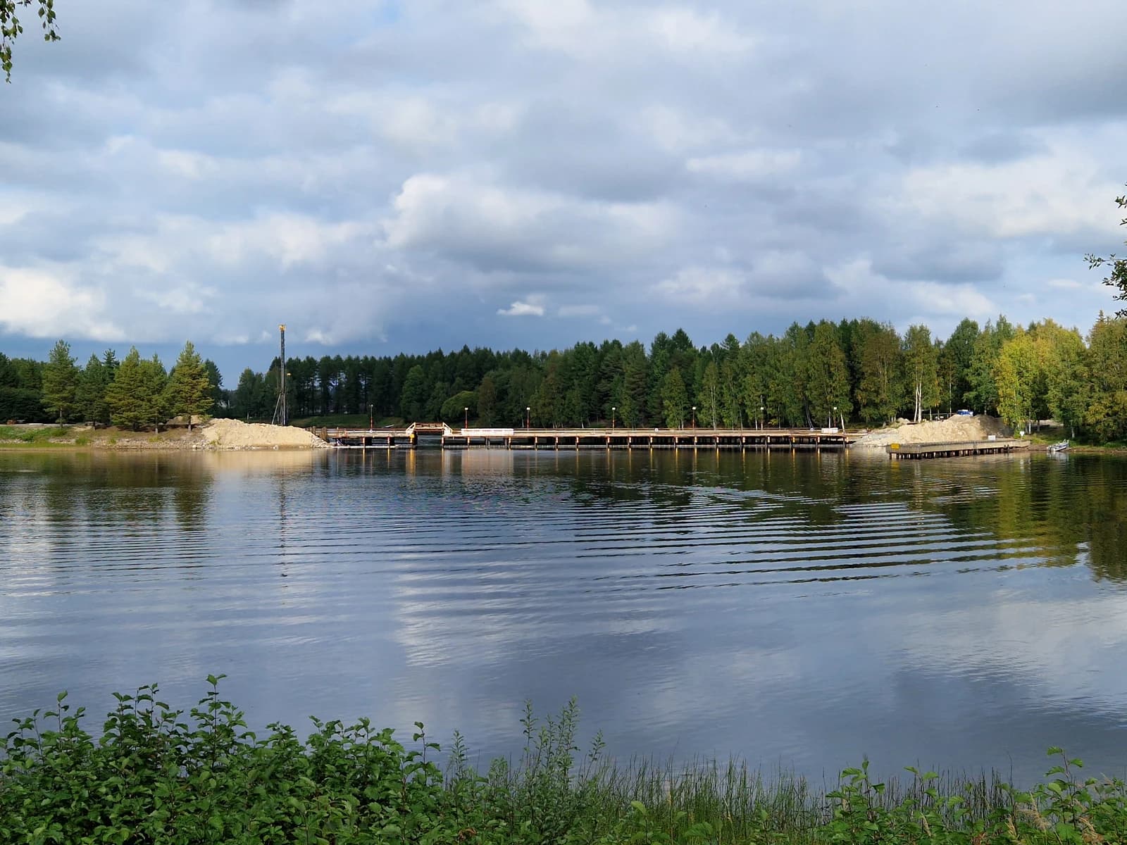 New Lieksanjoki bridge construction site in Finland with water and trees.