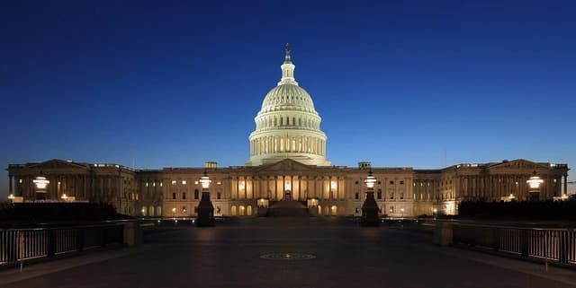 United States Capitol Building exterior at dusk, with illuminated dome and facade.