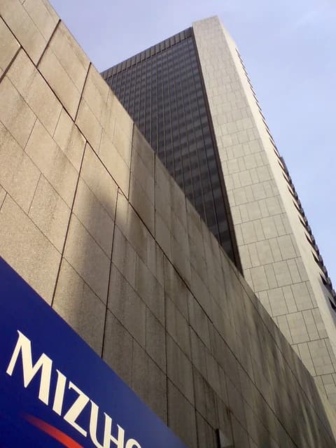 Mizuho Bank Ltd. head office towering against a clear sky.