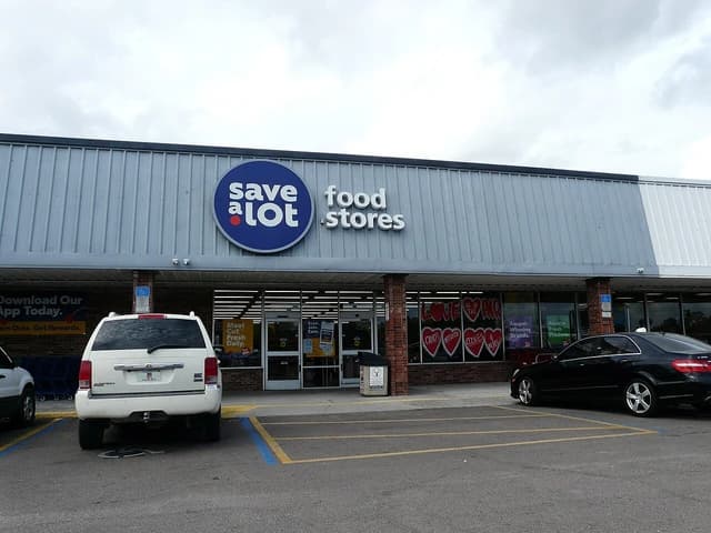 Exterior of a Save-A-Lot grocery store with parked cars in front of the entrance.