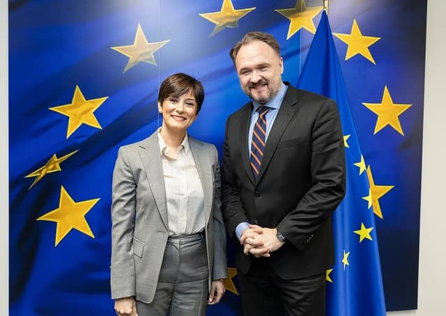 Isabel Rodríguez and Dan Jørgensen standing in front of European Union flag.