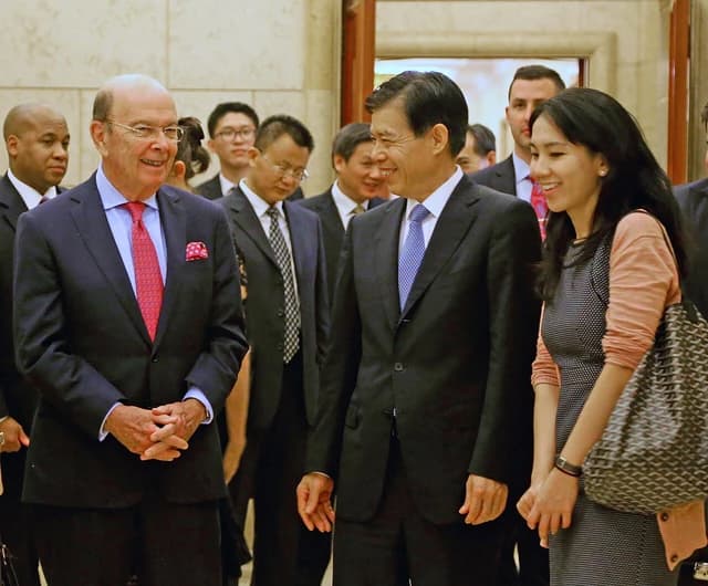 Secretary Ross and Minister Zhong Shan walking and smiling in a formal setting.