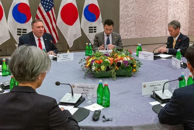 Mike Pompeo, US Secretary of State, seated at a table with other diplomats.