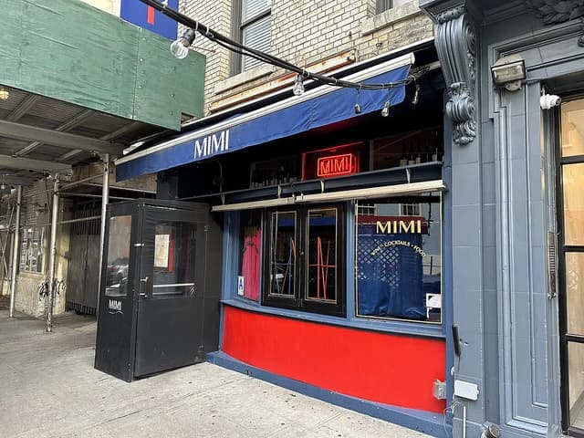 Exterior view of Mimi restaurant on a city street, with awning and signage visible.