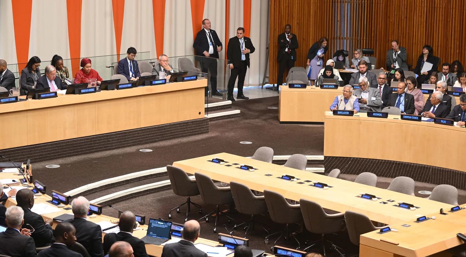 Muhammad Yunus speaking at a podium in the UN Headquarters during a summit.