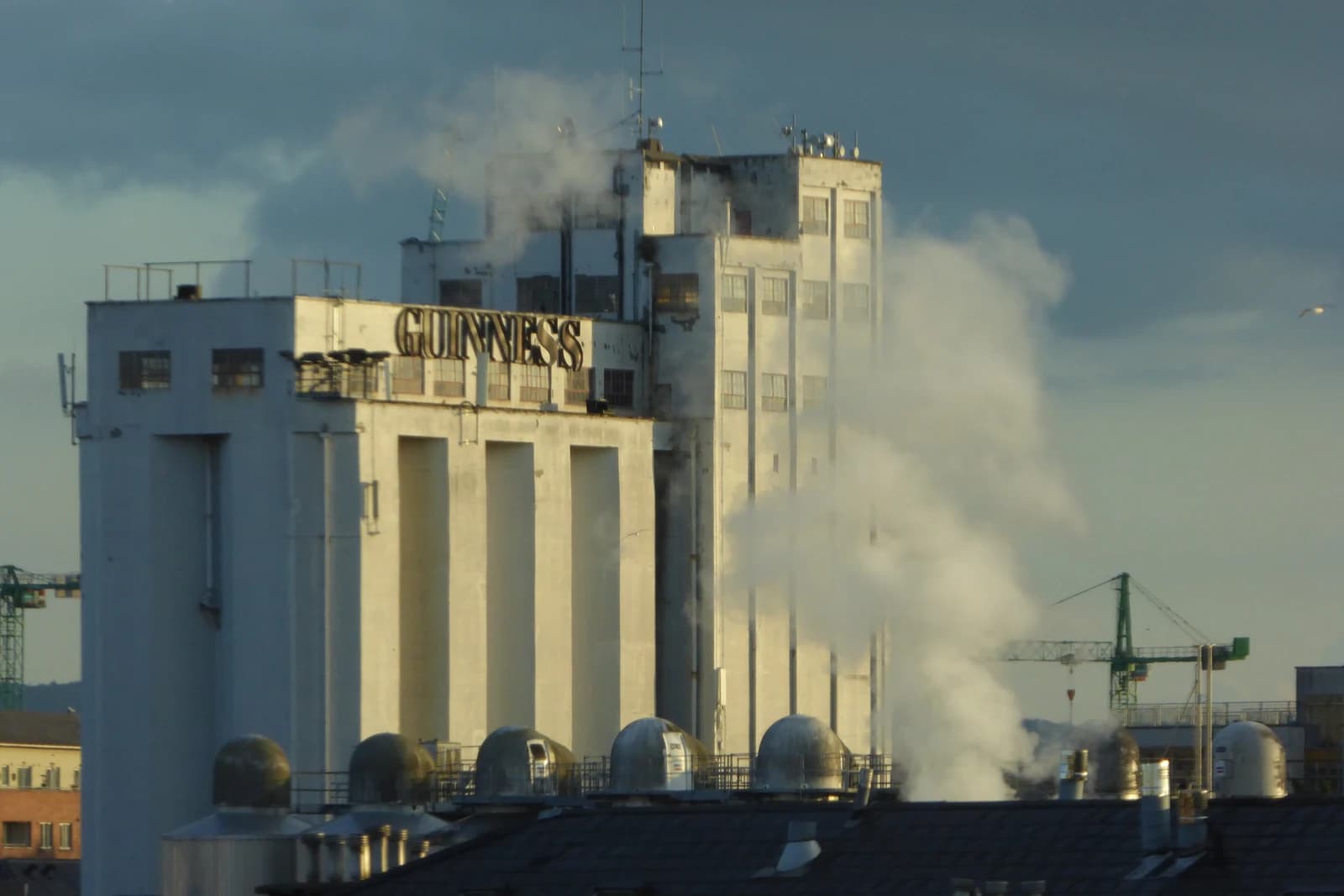 Guinness brewery building in Dublin with a visible sign and steam.